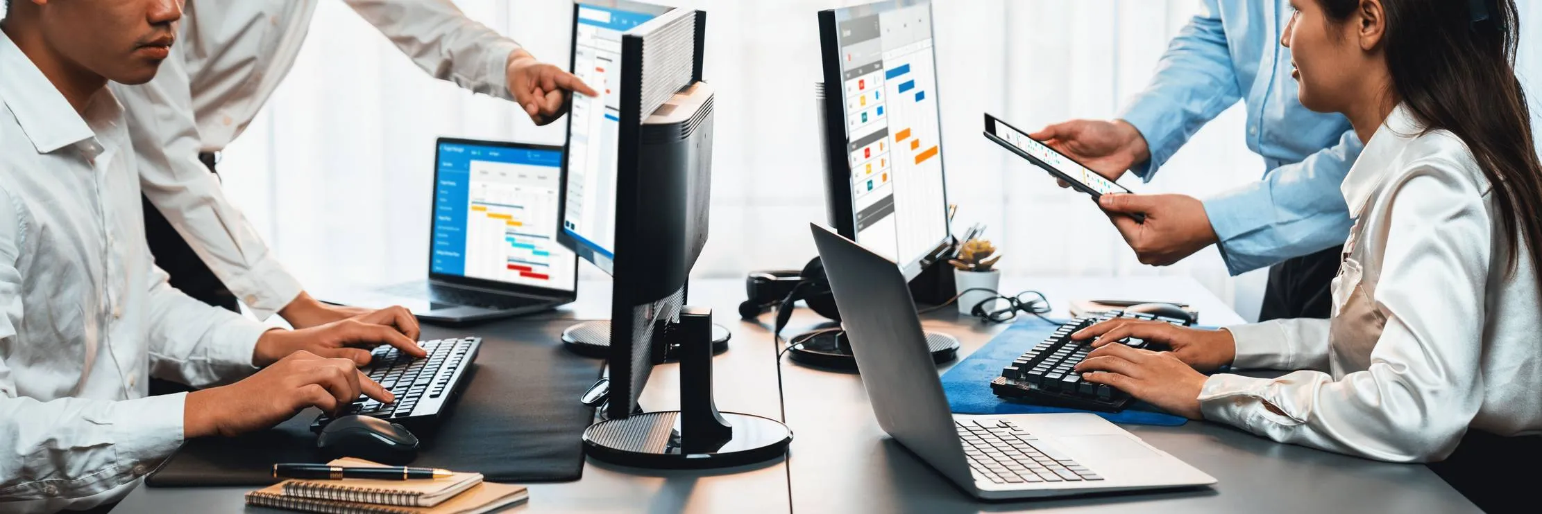 Équipe de professionnels travaillant avec plusieurs systèmes numériques de gestion d'entreprise