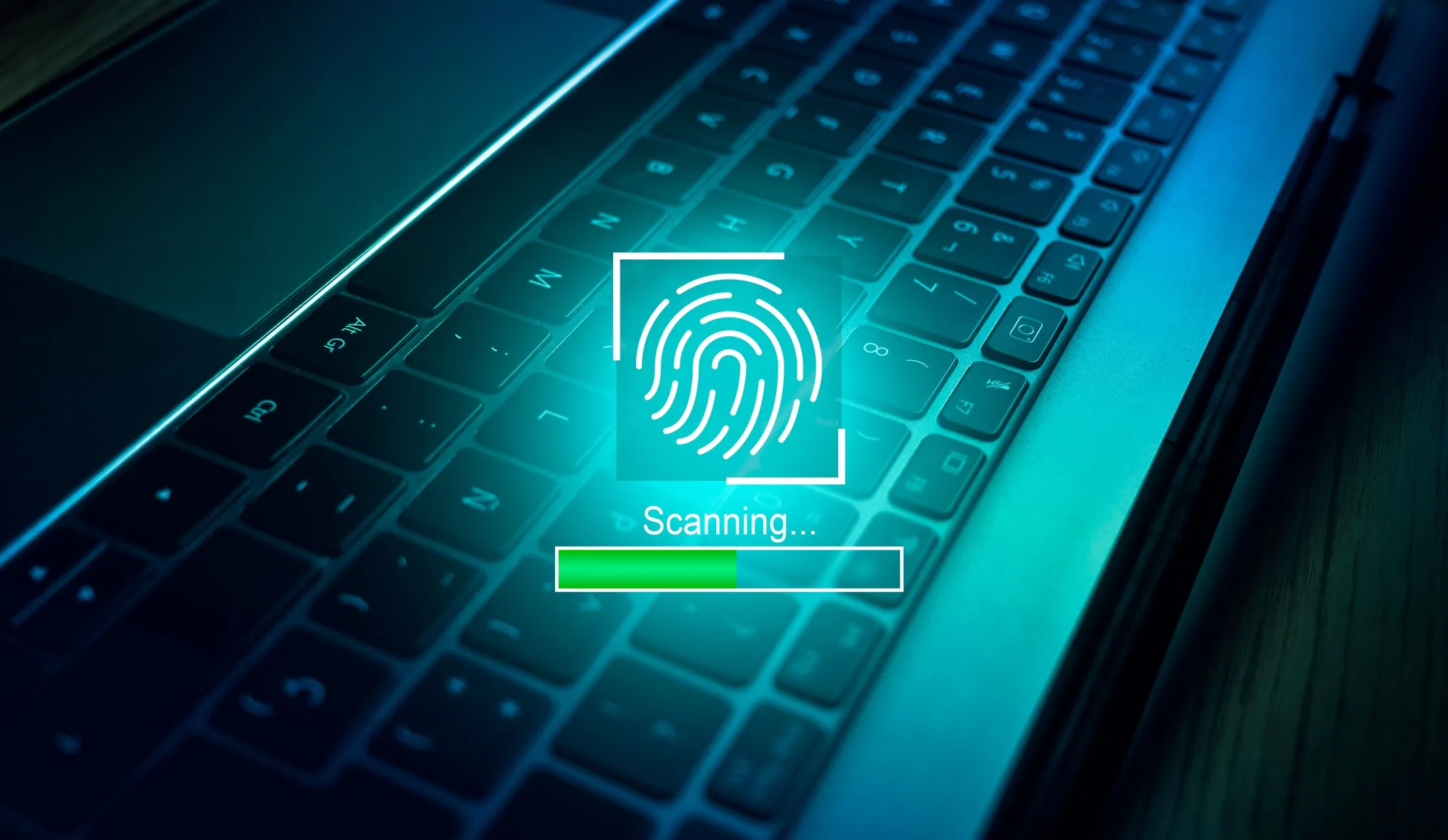 Fingerprint authentication scan over a laptop keyboard, representing a review of staff access to business systems