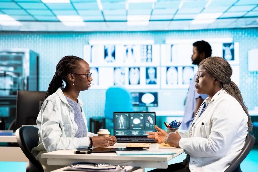 Clinician consulting with a patient, representing AI that supports triage while the human keeps the decision