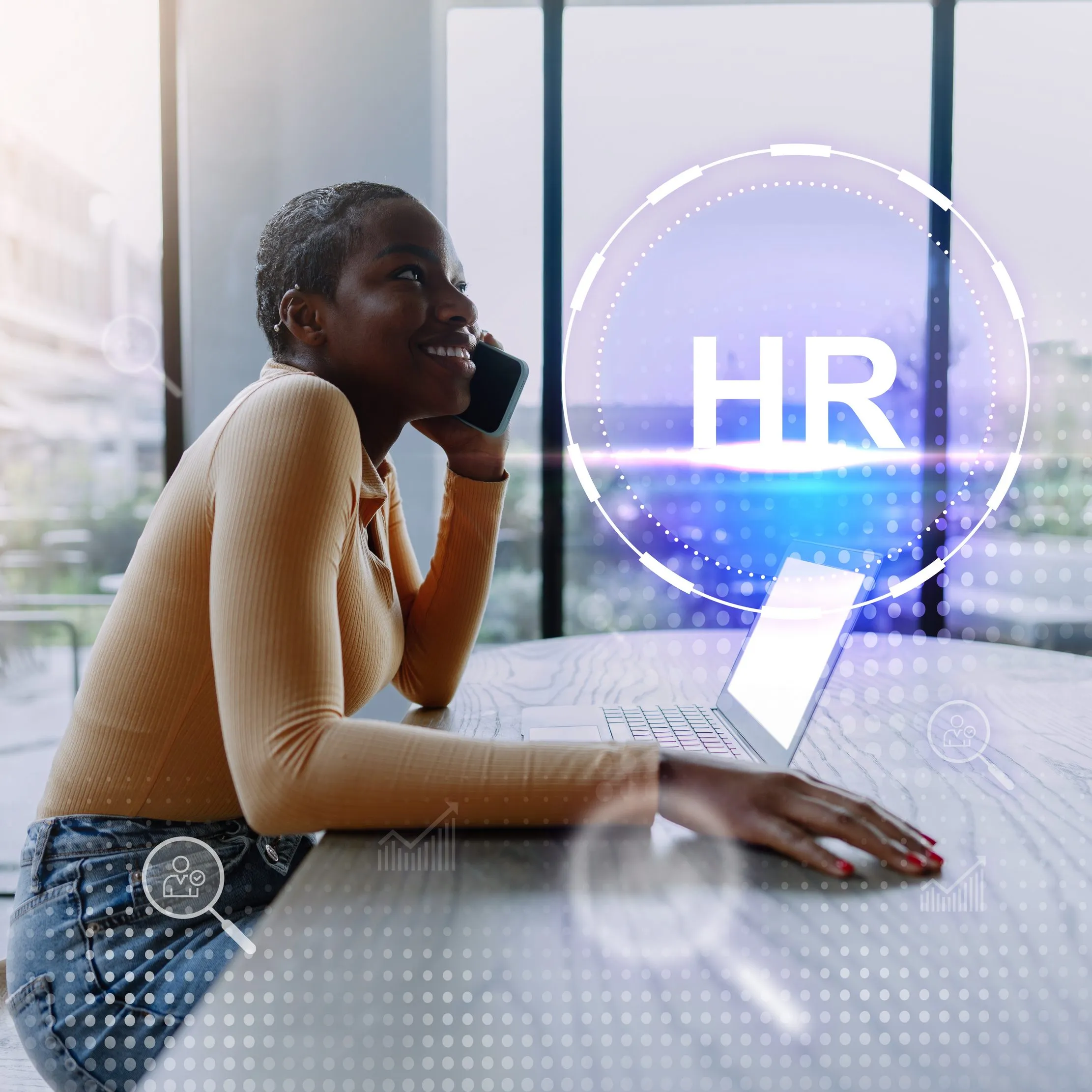 Young professional using a laptop and phone during a recruitment workflow, representing transparent candidate communication