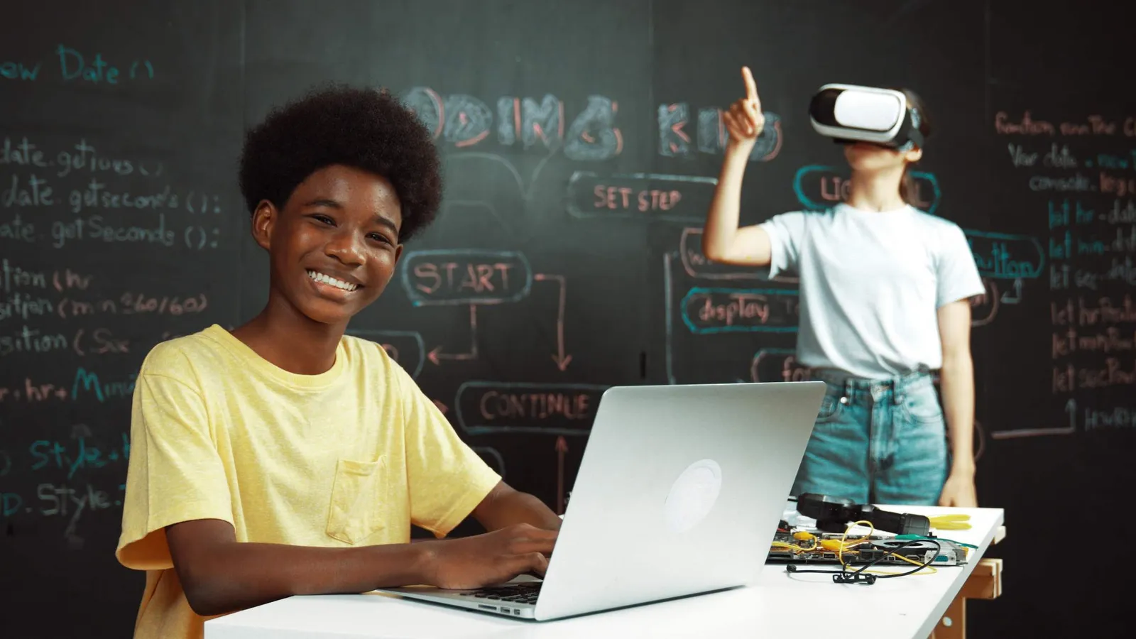 Students learning to code and use AI on laptops in a modern classroom