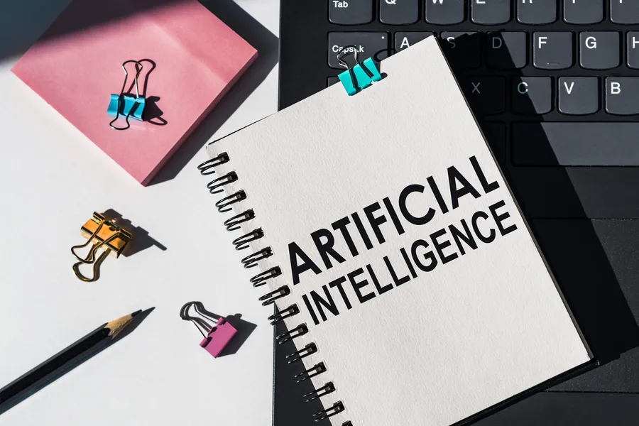 Notebook and laptop with artificial intelligence notes and tools, representing AI capability diagnosis and planning