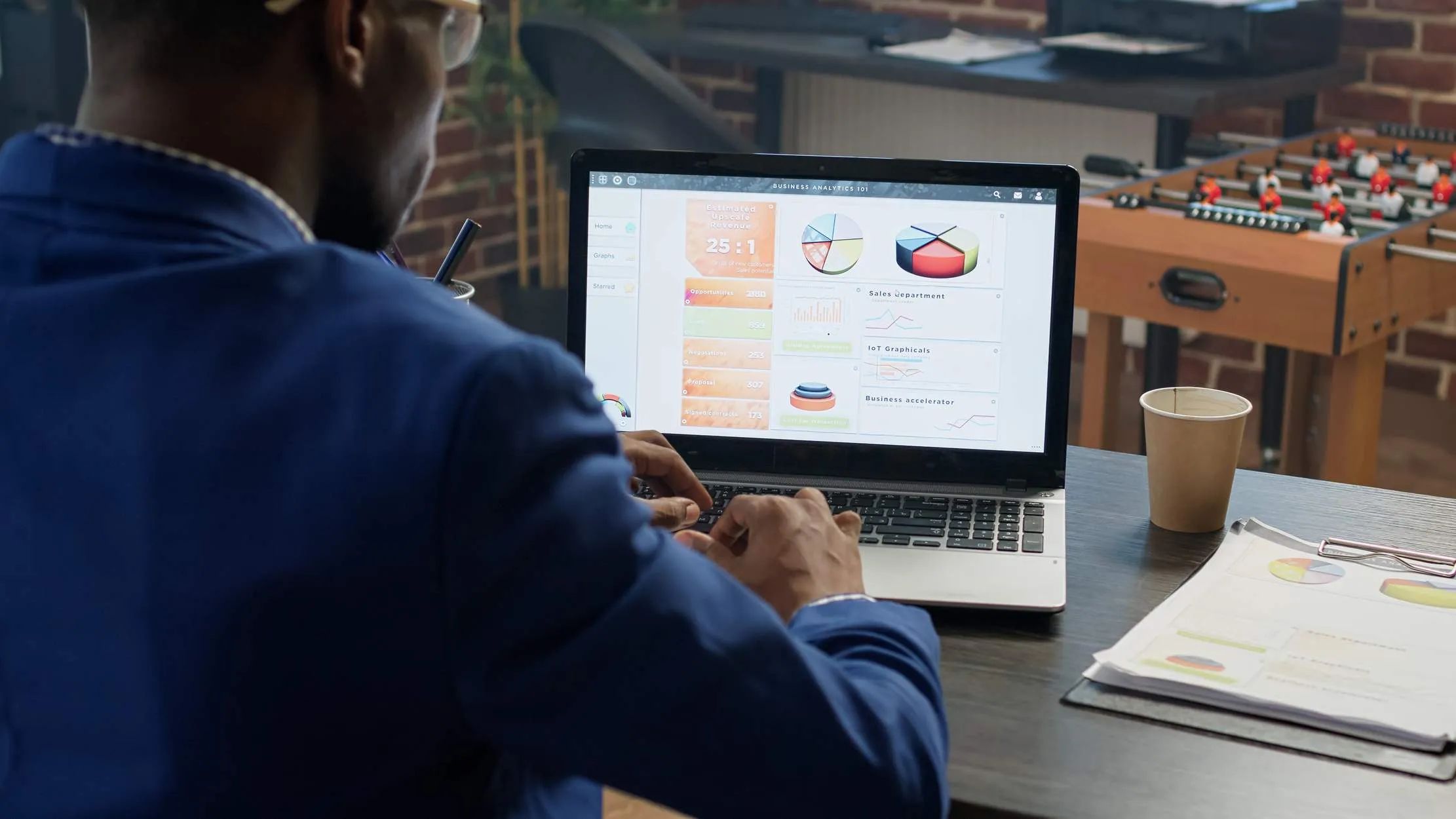 Office worker analysing business charts and project data on laptop