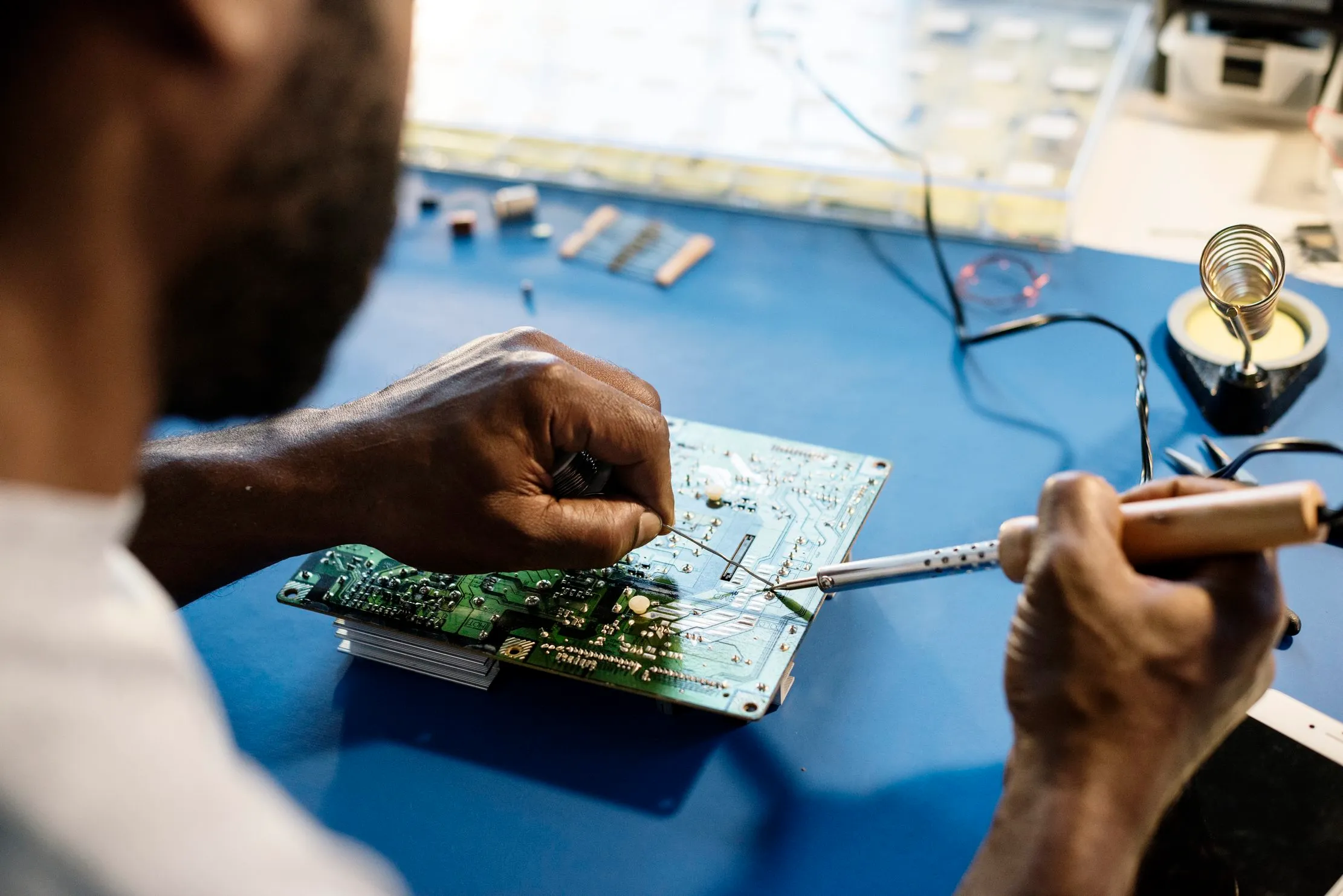 Technician soldering a circuit board, illustrating repair as the first ICT lifecycle decision