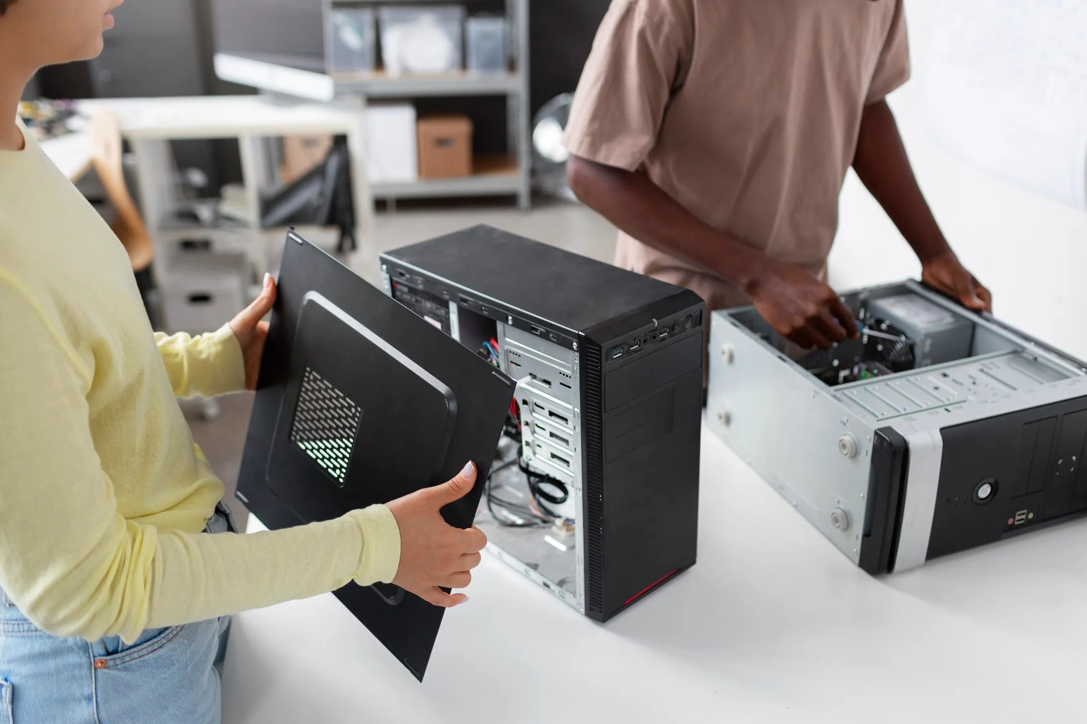 Technicians opening desktop computer cases during a maintenance inspection