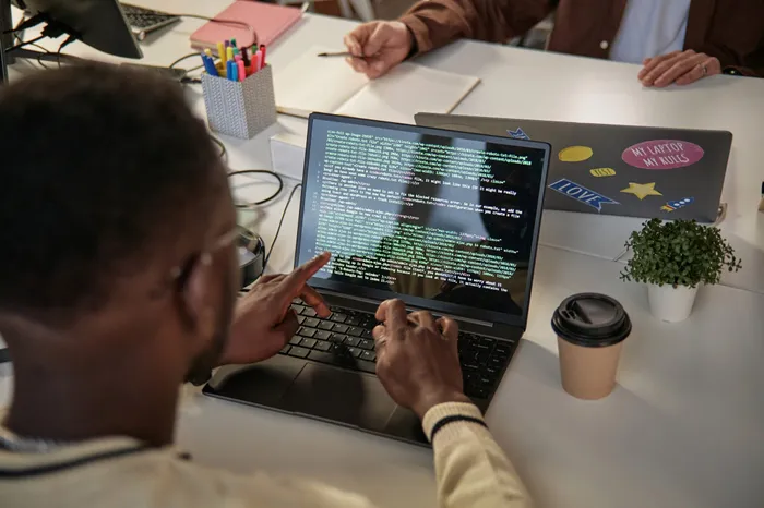Developpeur logiciel verifiant du code avant un deploiement multi-pays en Afrique