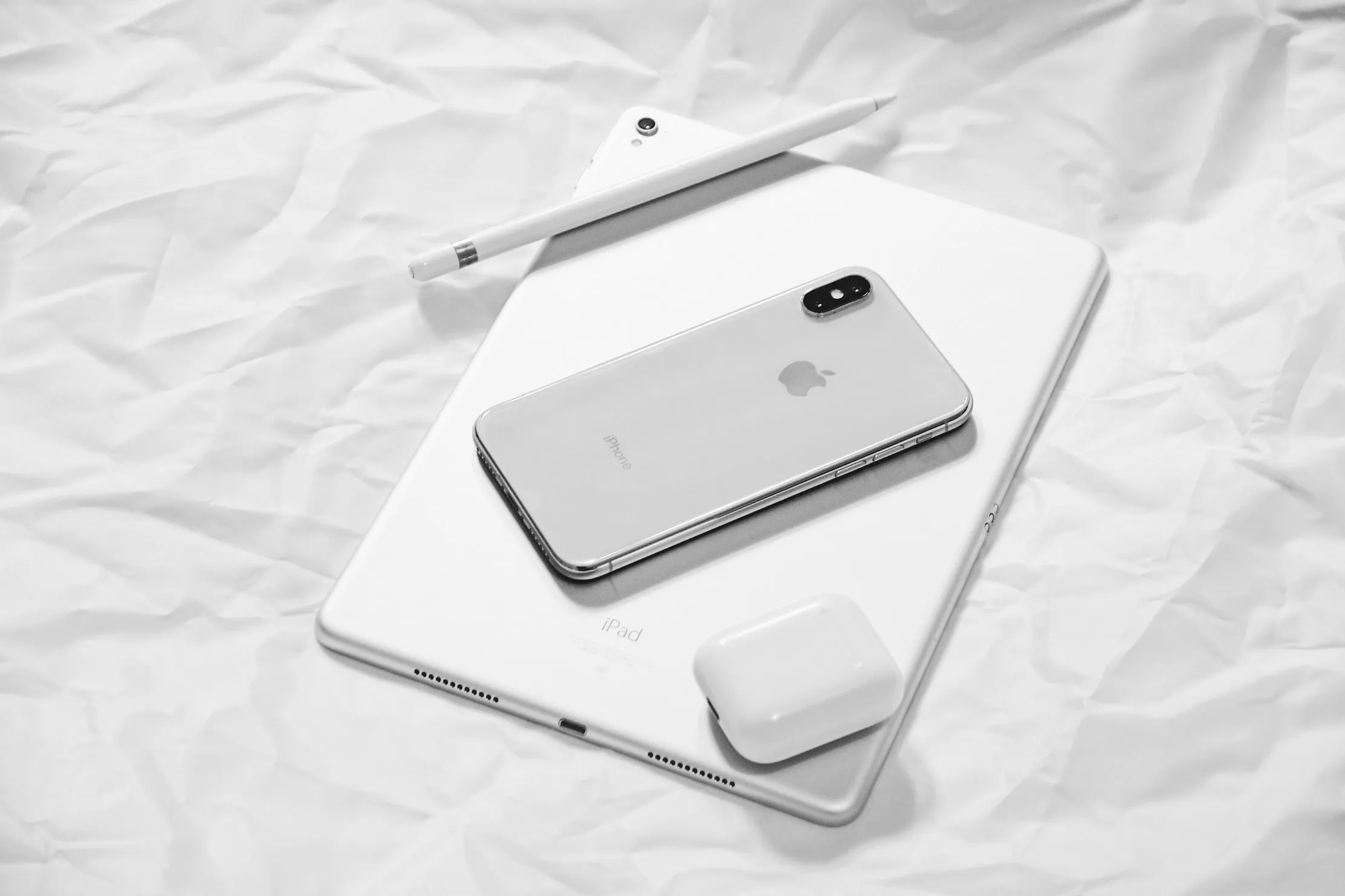 Ensemble d iPhone, iPad et accessoires Apple sur une table blanche