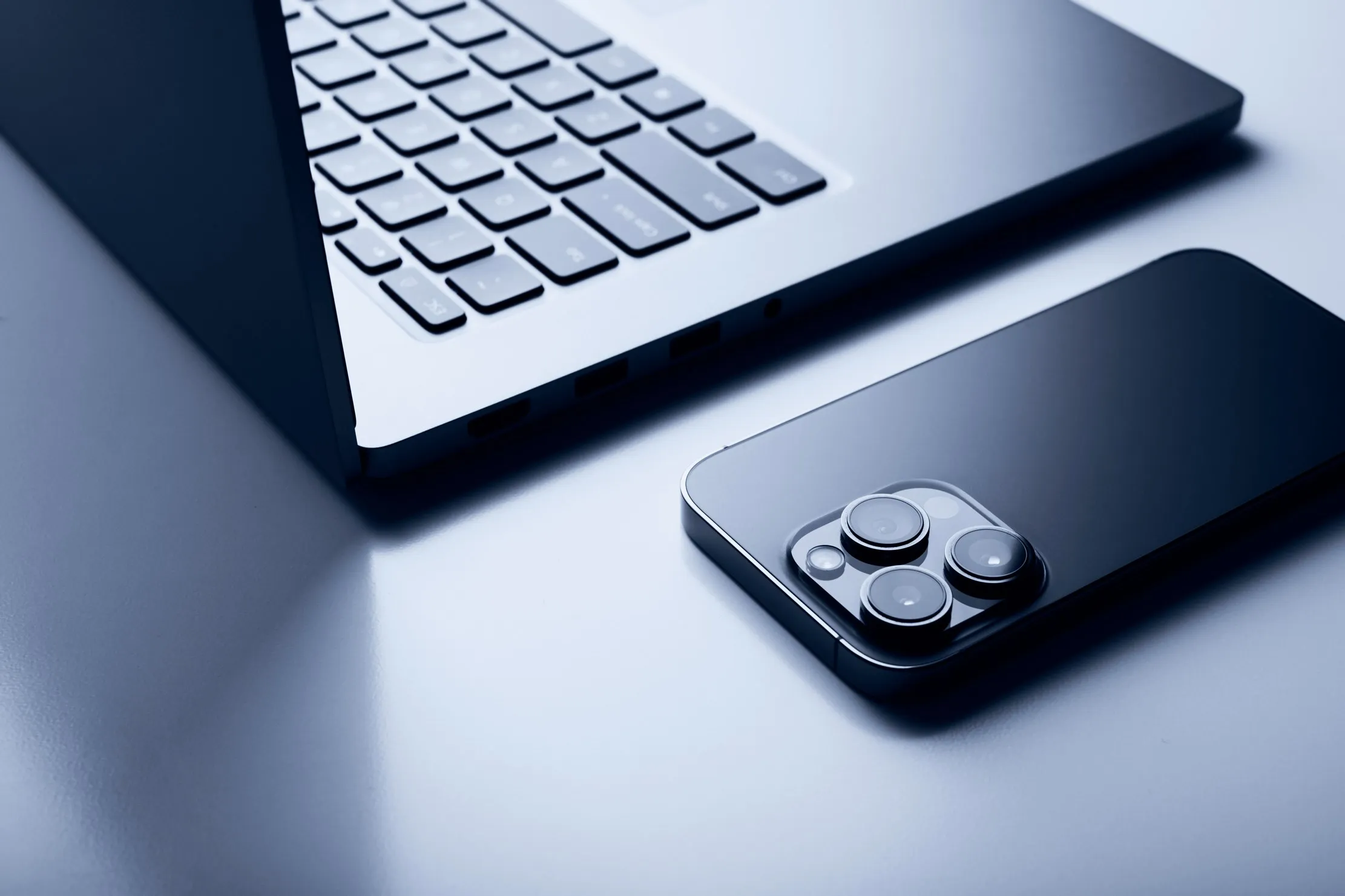 MacBook et iPhone sur un bureau, representant la migration vers Xcode 27 sur Apple Silicon