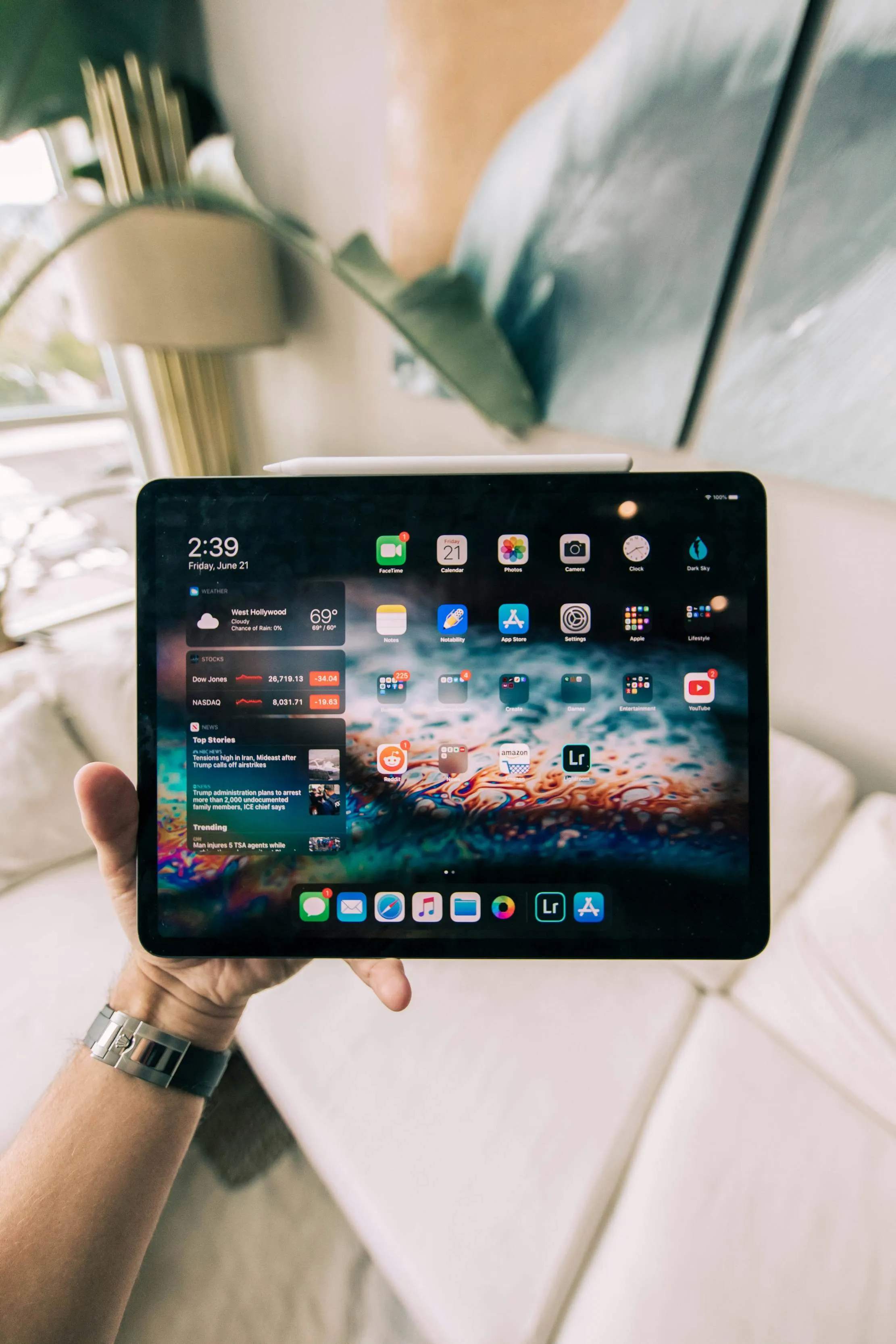 iPad tenu dans une main, representant les surfaces adaptatives iPadOS